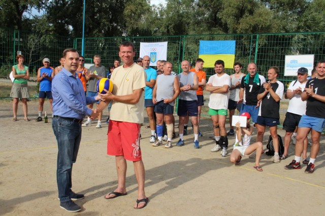 Подарунок від місцевої влади, який вручає Голова Дніпровської райдержадміністрації  Ярослав Горбунов для Волейбольного клубу «Тельбін», отримує його представник Юрій Дещенко 